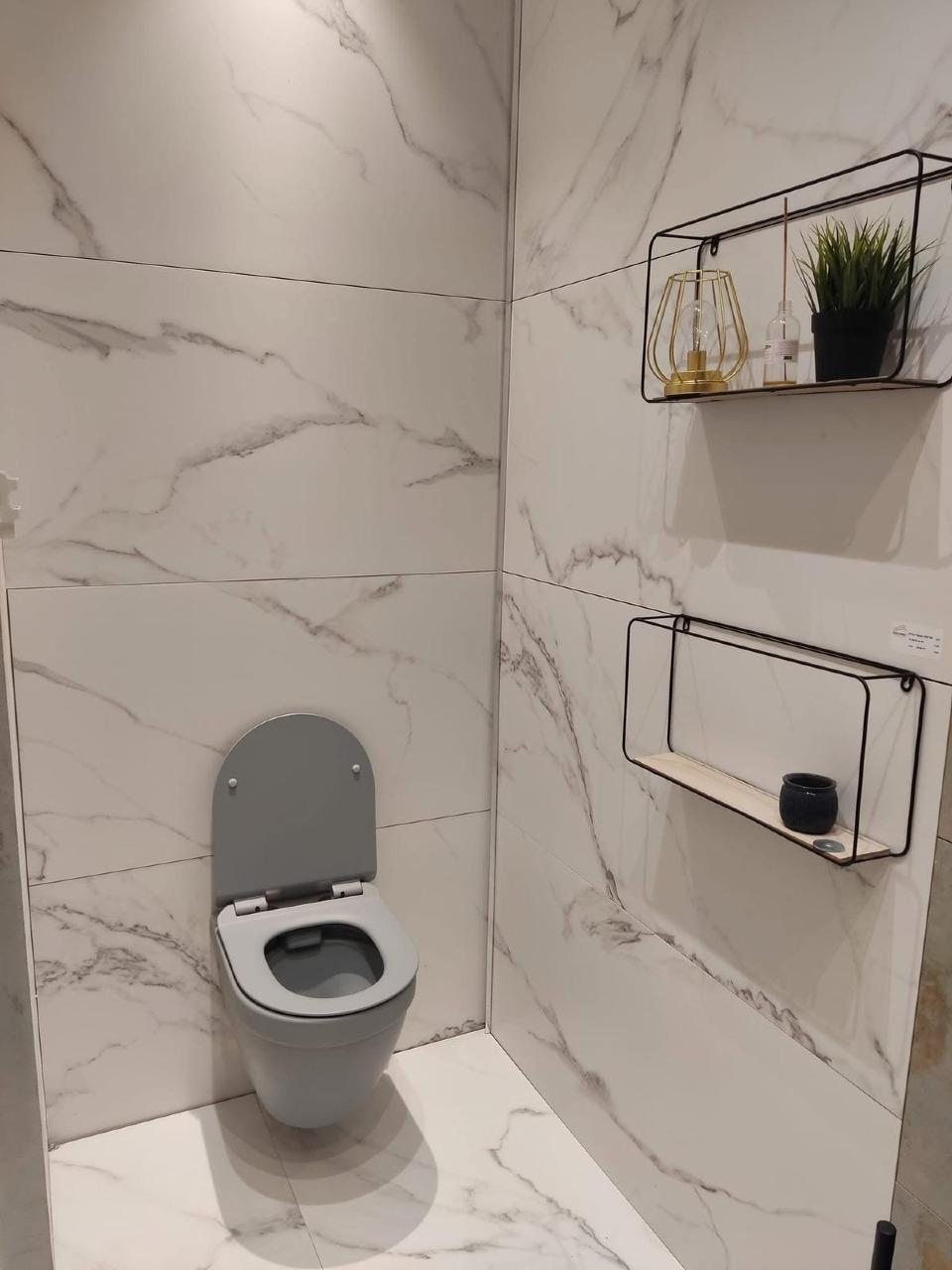 שירותים בחיפוי שיש לבן עם מדפי מתכת שחורים