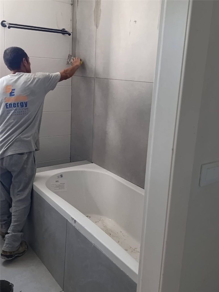 חיפוי הקירות באריחים גדולים מעל האמבטיה
